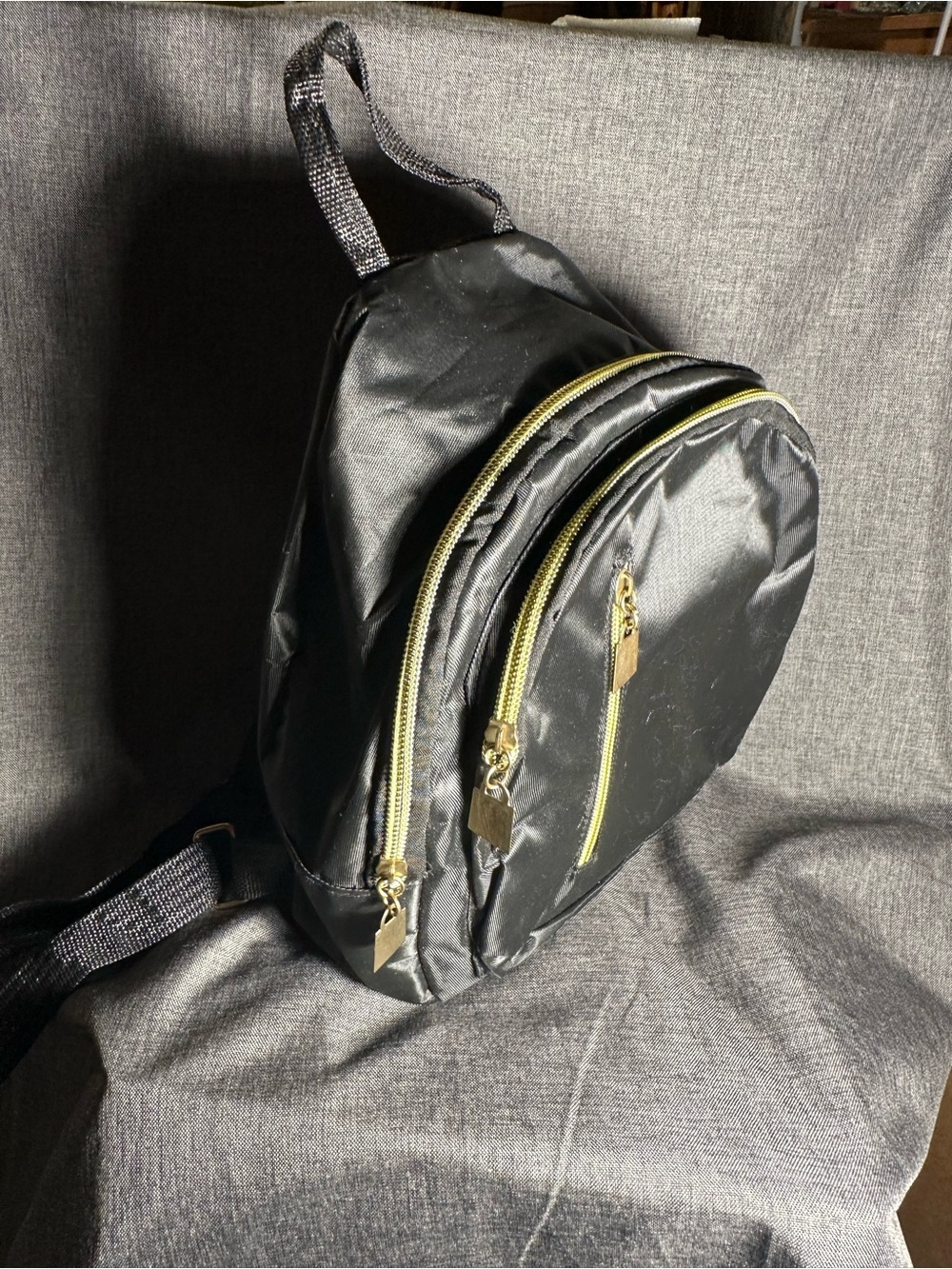 Sleek Black Crossbody Backpack with Gold Accents